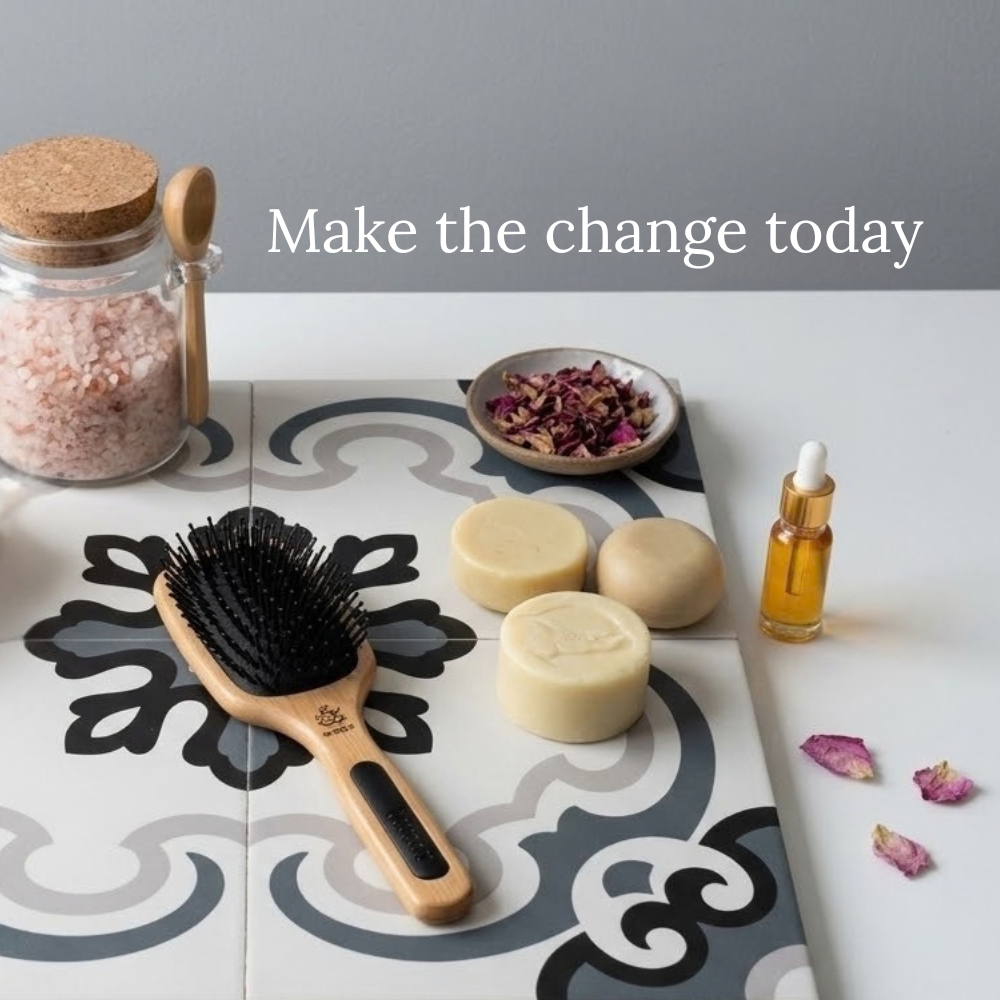 Picture of a plastic free hair washing experience, 3 solid shampoo bars which are at various stages of use, ha bottle of hair and scalp oil. a glass jar of Himalayan salt and a wooden hairbrush all laid out on bathroom tiles. With the words Make the change today