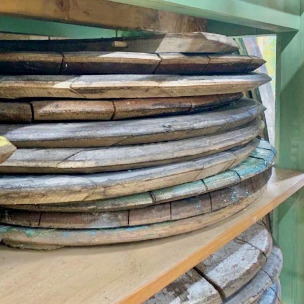 Reclaimed whisky cask lids stacked ready for crafting into oak serving boards