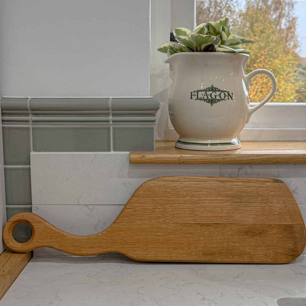 reclaimed oak whisky lid paddle board with unique handle, displaying a slice of banana cake on a napkin, and vintage crockery nearby