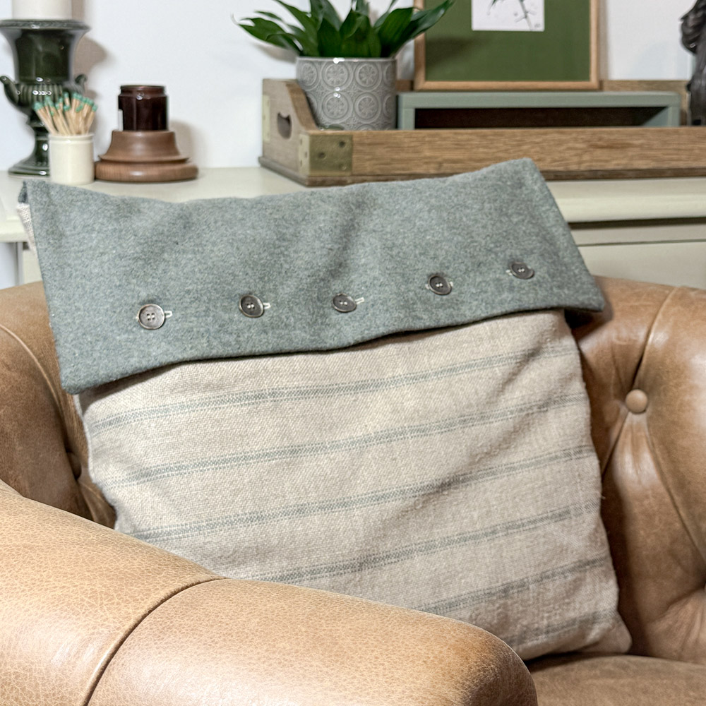 Scottish wool fabric and scottish linen fabric cushions in a muted teal and railroad stripe in a brown leather armchair