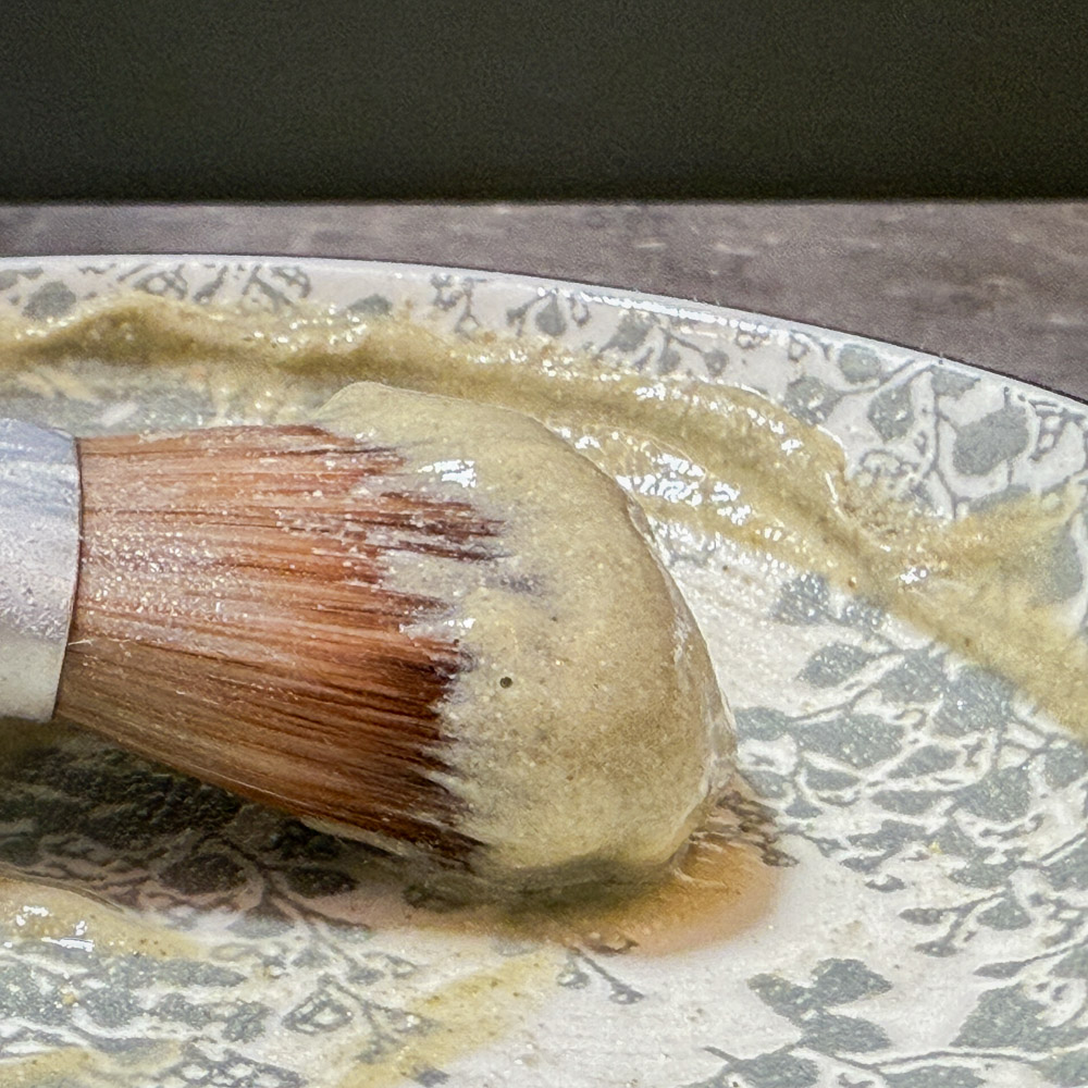 refine purifying facial masque being mixed on a ceramic plate to form a creamy paste