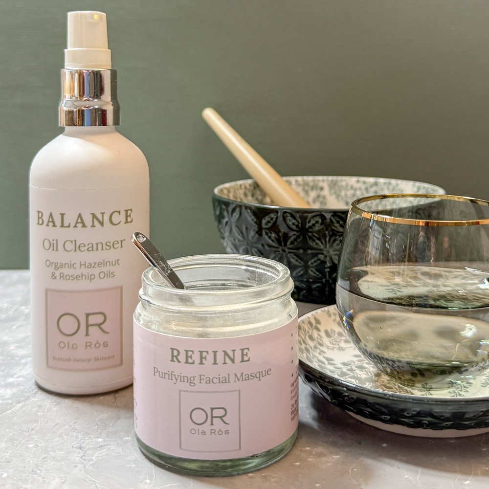 Balance oil cleanser and refine purifying facial masque and water together with a bowl a scoop and a make up brush ready to mix together