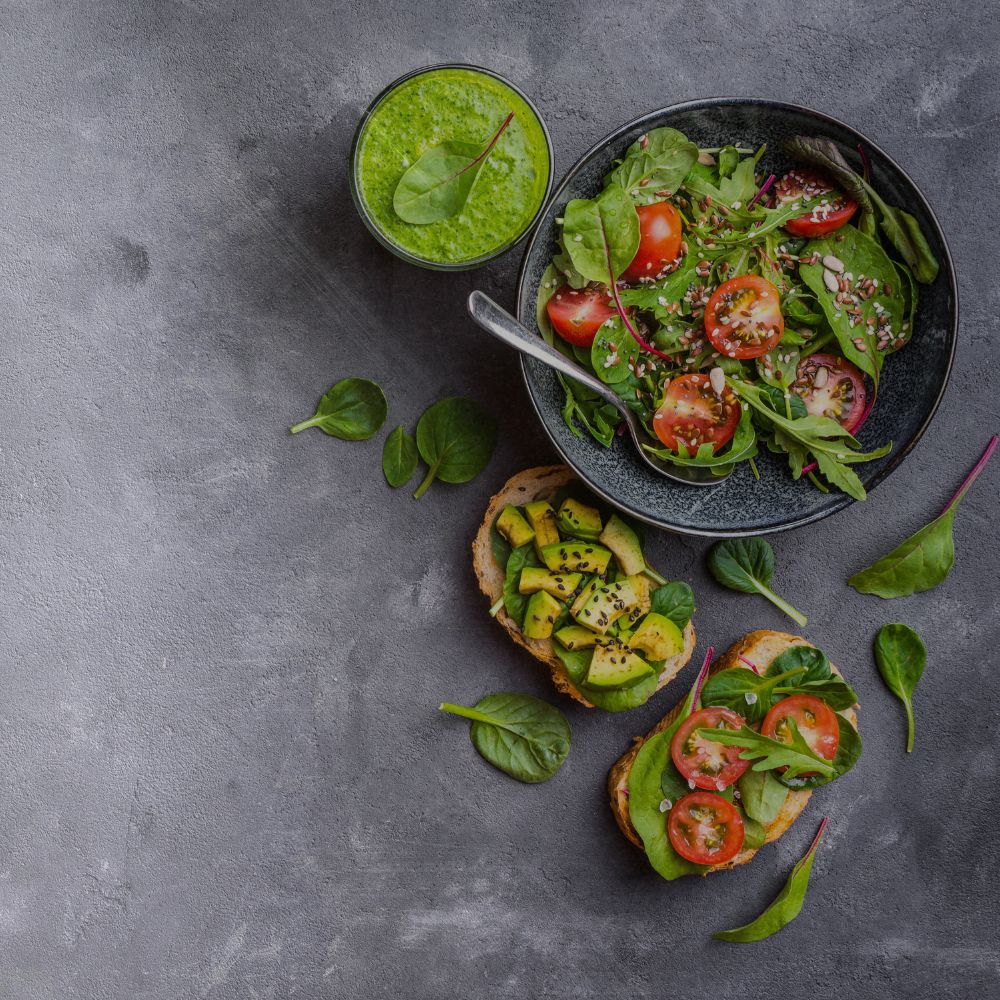 an image of healthy eating., a tomaote and avocado salad on a dark grey background. healthy eating is part of having a healthy skin barrier