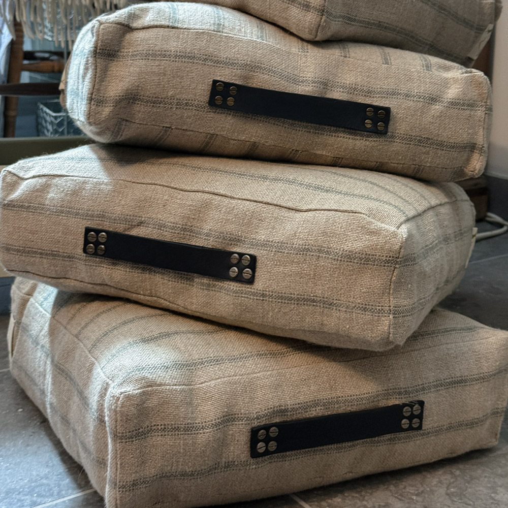 stack of floor cushions by Made in the Glen railroad stripe linen stuffed with British Wool and finished with blue leather handles