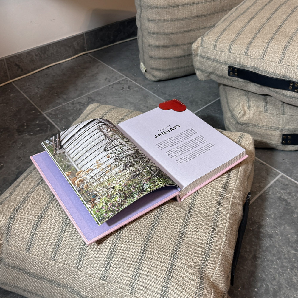 floor cushions by Made in the Glen railroad stripe linen stuffed with British Wool and finished with blue leather handles. One of the cushions has a gardening book open and laid on top of it