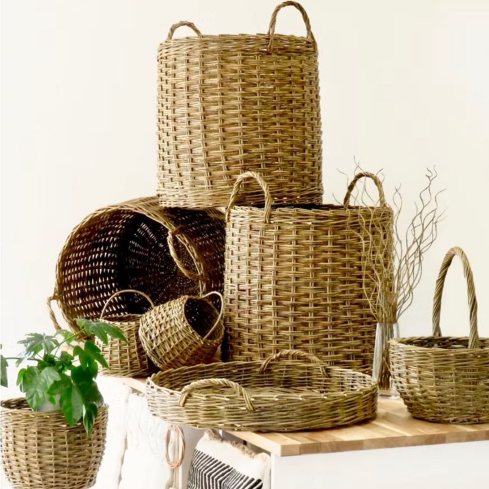 a selection of willow baskets and trays on a table and a white background to display items made by Highland Willow