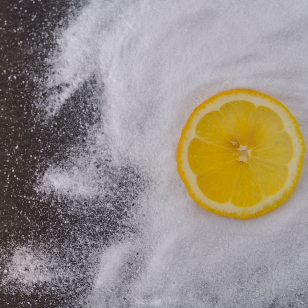 a slice of lemon and some bicarbonate of soda ingredients for making a citrus shine cleaner for sinks and chopping boards.