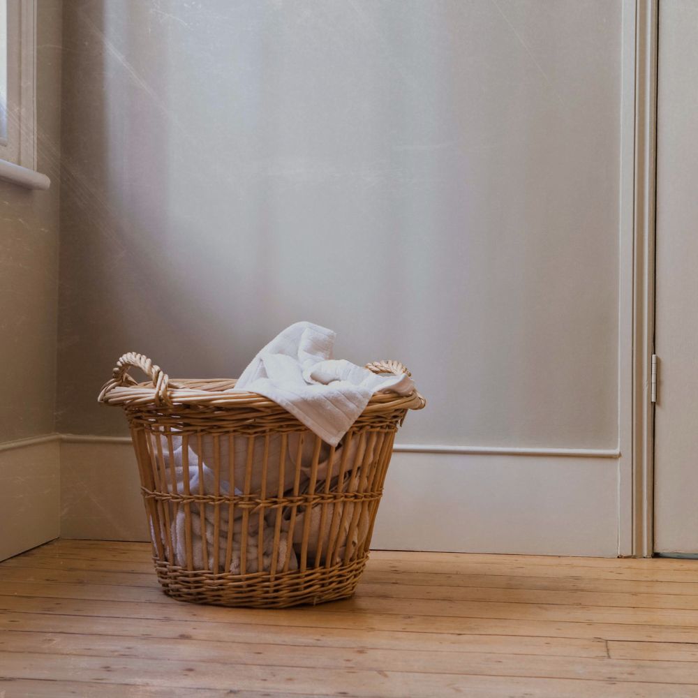 a basket of laundry in the corner of a room