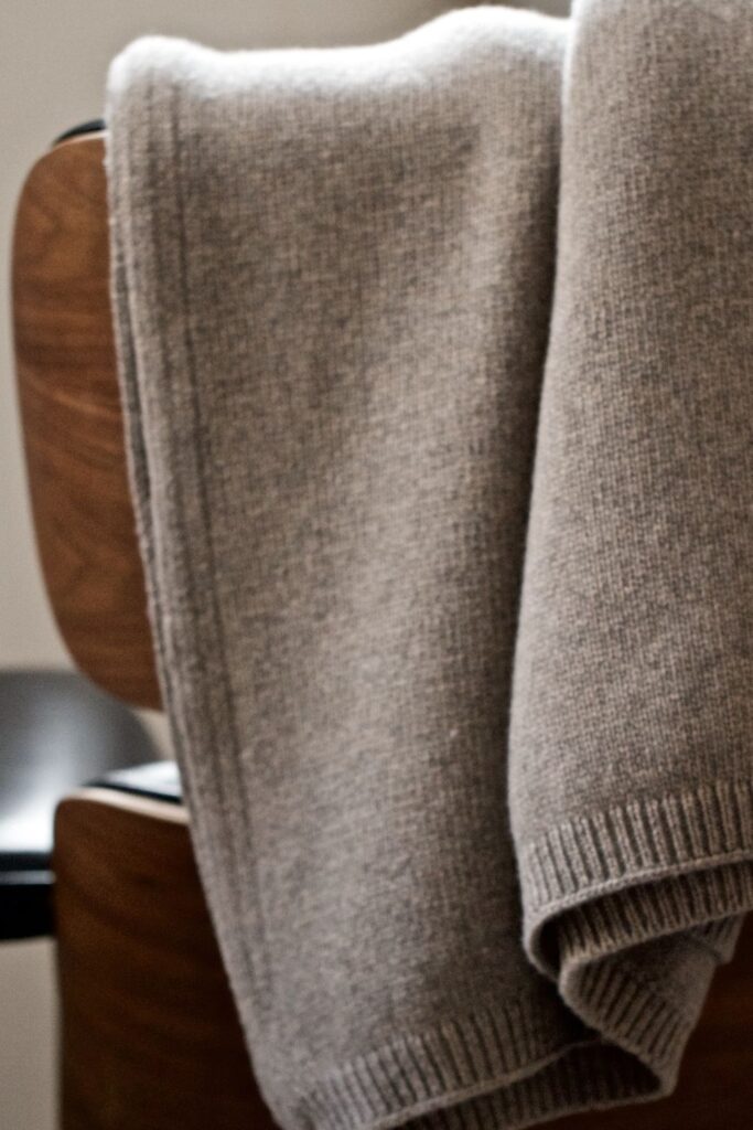 a cashmere jumper laid over the back of a chair
