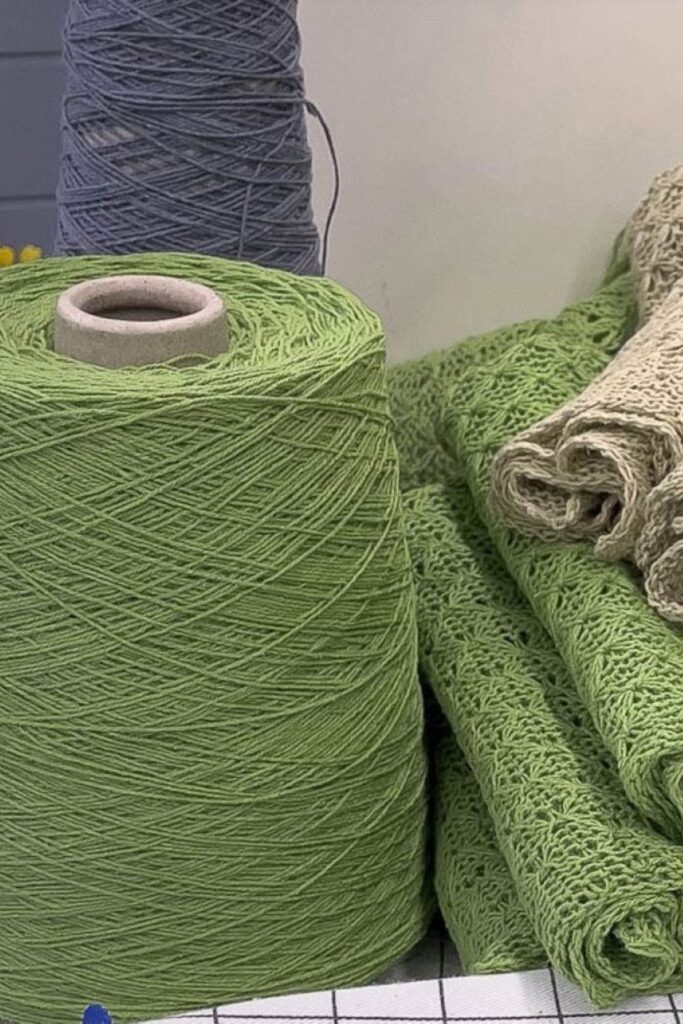 a cone of recycled linen yarn and knitted facecloths besides